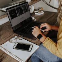 Computers with a person infront who has their hands on mouse and keyboard